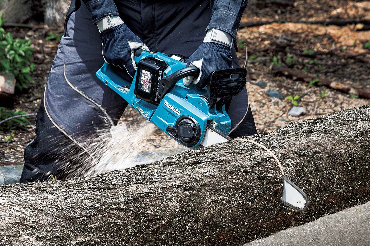 Persoon zaagt boomstam met accukettingzaag
