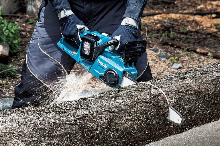 Persoon zaagt boomstam met accukettingzaag