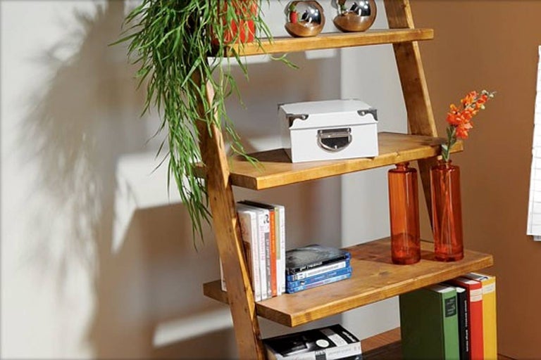 Houten ladderrek met decoratieve objecten zoals planten, vazen en boeken