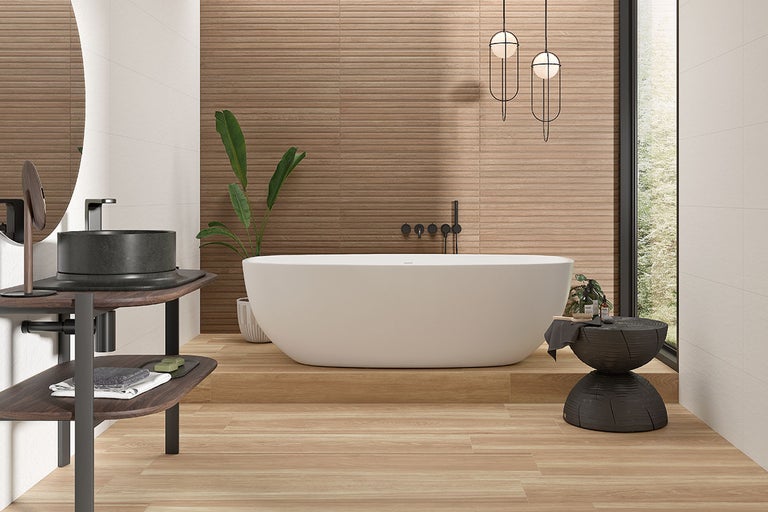 Moderne badkamer met vrijstaand bad, wastafel met ronde waskom en wandtegels met houtlook.