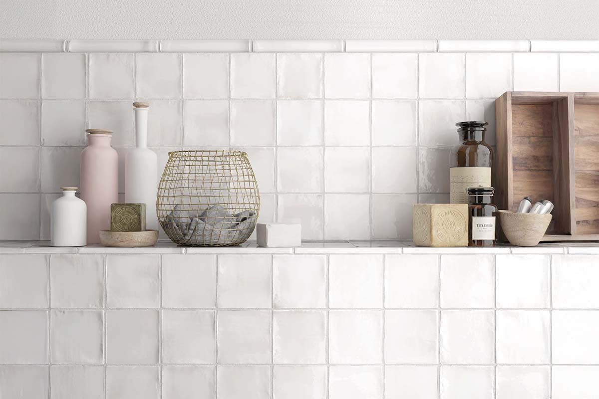 Scène met witte, vierkante wandtegels en decoratiespullen op een plank