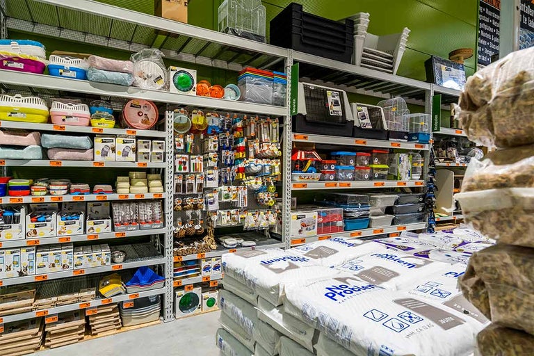 Stellingen met dierbenodigdheden zoals transportboxen, kooien, voerbakken en kattenbakvulling in de Hornbach winkel.