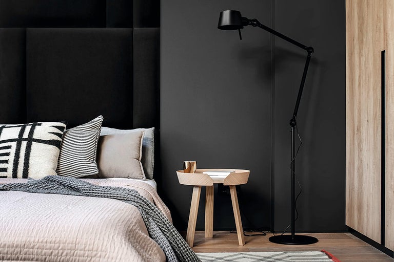 Slaapkamer met bed, nachtkastje, vloerlamp en wandpanelen