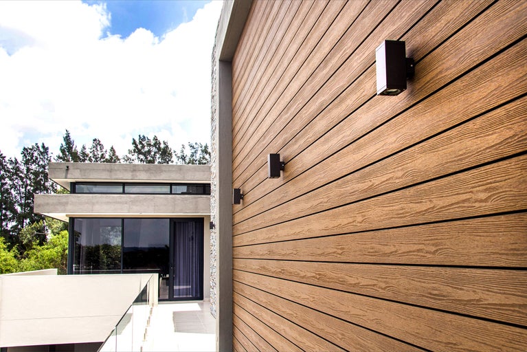 Gevel met houten bekleding en buitenverlichting op een modern huis