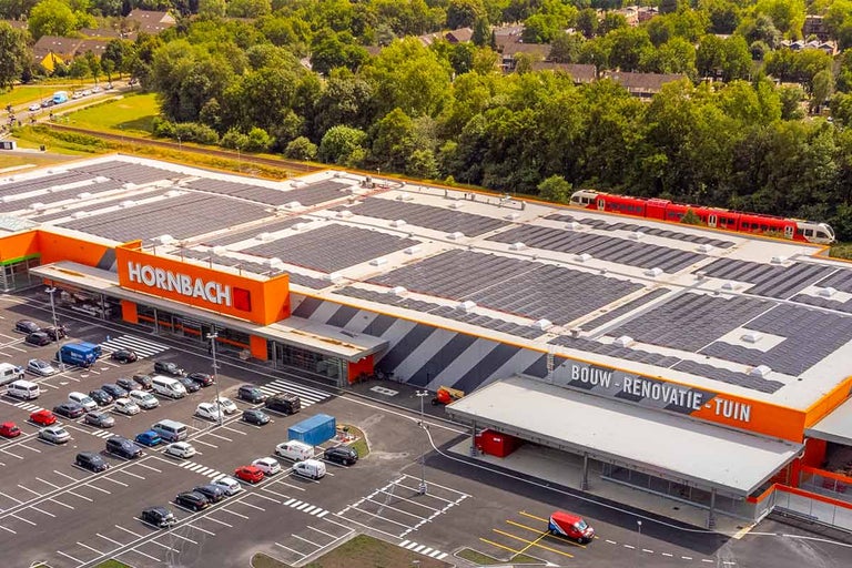 Luchtfoto van een Hornbach bouw- en tuinmarkt met parkeerplaats en zonnepanelen op het dak