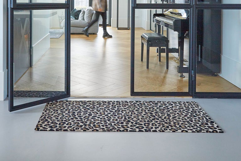 Deurmat met dierenprint voor een glazen deur in een hal