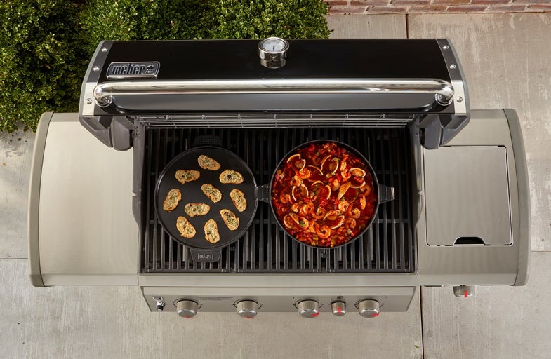 Weber barbecue met eten in pan en op grillplaat