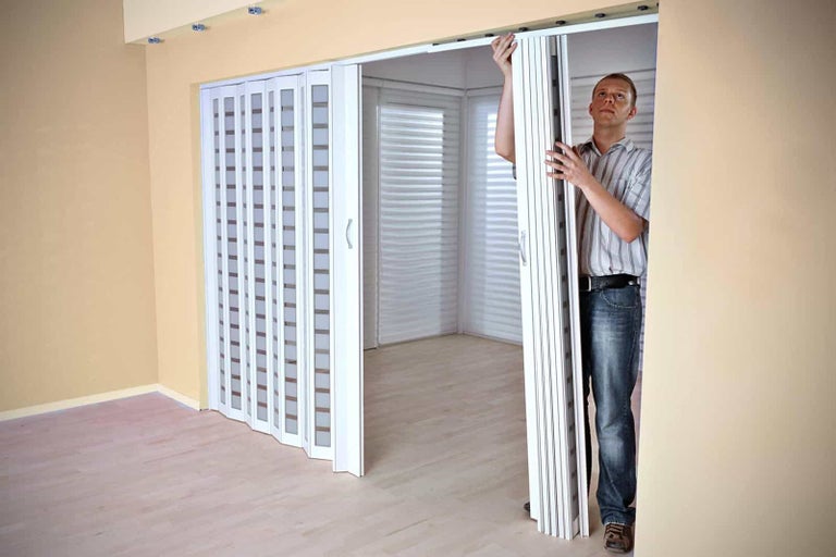 Man monteert een vouwdeur binnenshuis