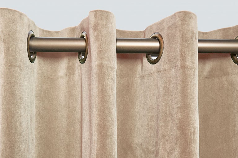 Gedetailleerde close-up van een gordijn met oogjes bevestigd aan een gordijnroede