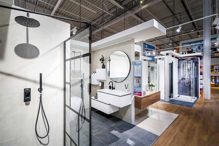 Showroom met wastafel, spiegel en douche in een bouwmarkt.