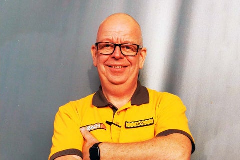 Een Hornbach medewerker met een naamplaatje kijkt in de camera.