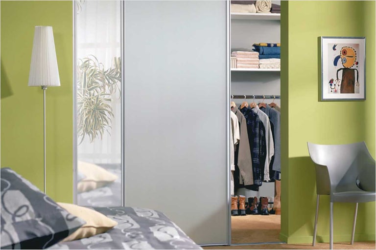 Slaapkamer met schuifdeurkast, staande lamp, bed en decoratie