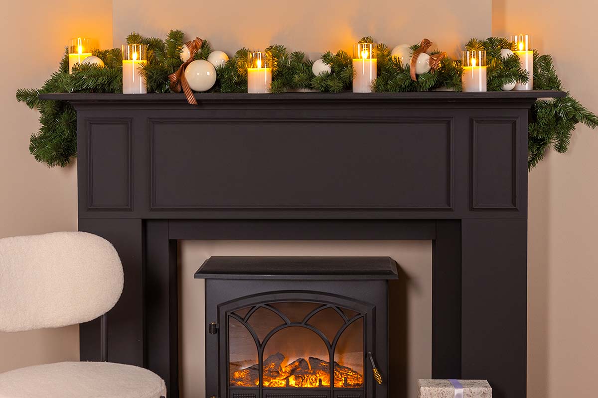 Decoratieve open haard met kerstversiering en ledkaarsen voor een feestelijke sfeer.