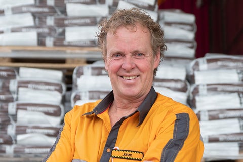 Een Hornbach-medewerker staat voor een stapel betonspeciezakken.