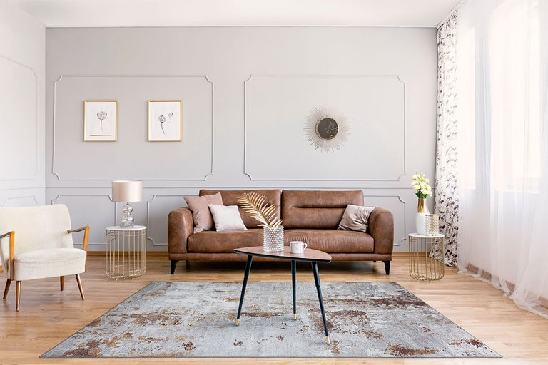 Woonkamer met bank, fauteuil, vloerkleed en tafel