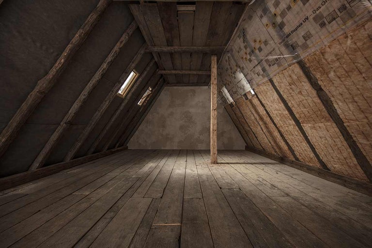 Zolder met houten balken, raam en thermische isolatie