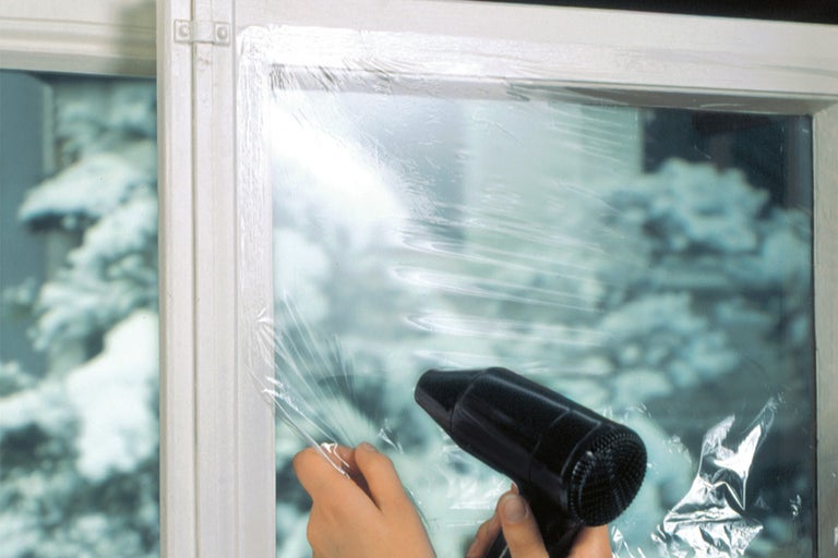 Raam met isolatiefolie en heteluchtpistool voor het aanbrengen van de folie