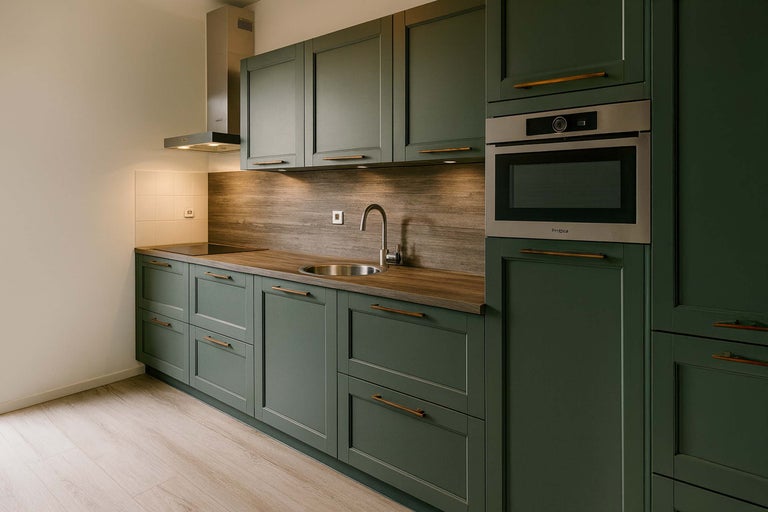 Moderne keuken met spoelbak, afzuigkap en ingebouwde oven.