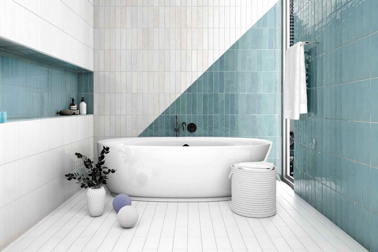 Moderne badkamer met witte en groene tegels, vrijstaand bad en decoratieve elementen.