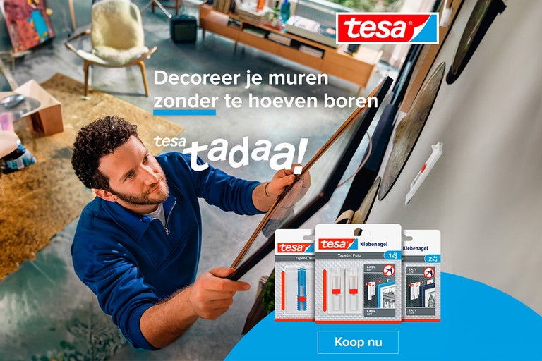 Man bevestigt fotolijst met Tesa plakspijkers aan de muur