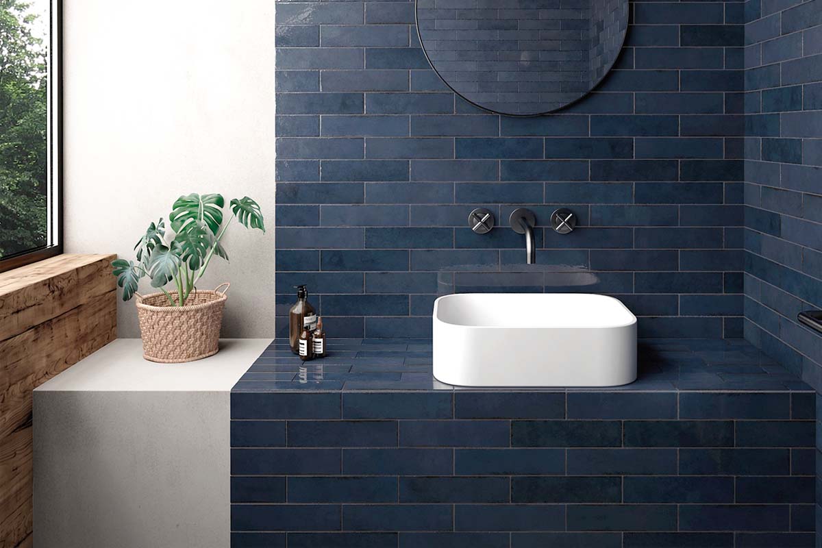 Moderne badkamer met blauw betegelde muren, opzetwastafel en spiegel