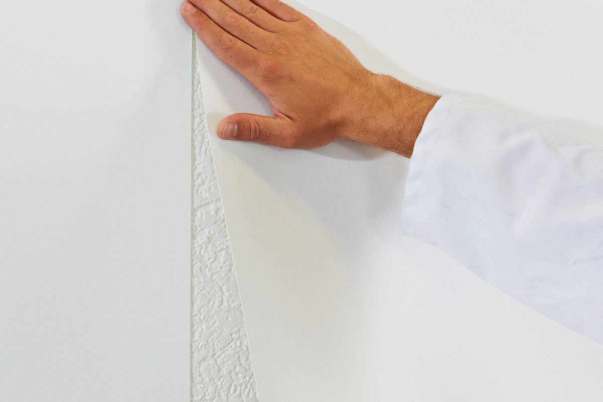 Hand drukt vliesbehang tegen structuurmuur