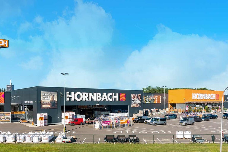 Hornbach bouwmarkt buitenaanzicht met parkeerplaats en klantenverkeer bij daglicht