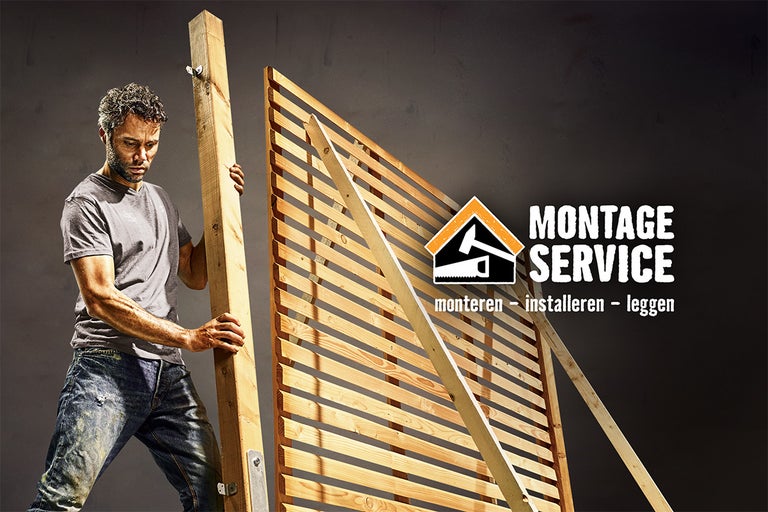 Man monteert een houten constructie, op de achtergrond Montage Service Logo