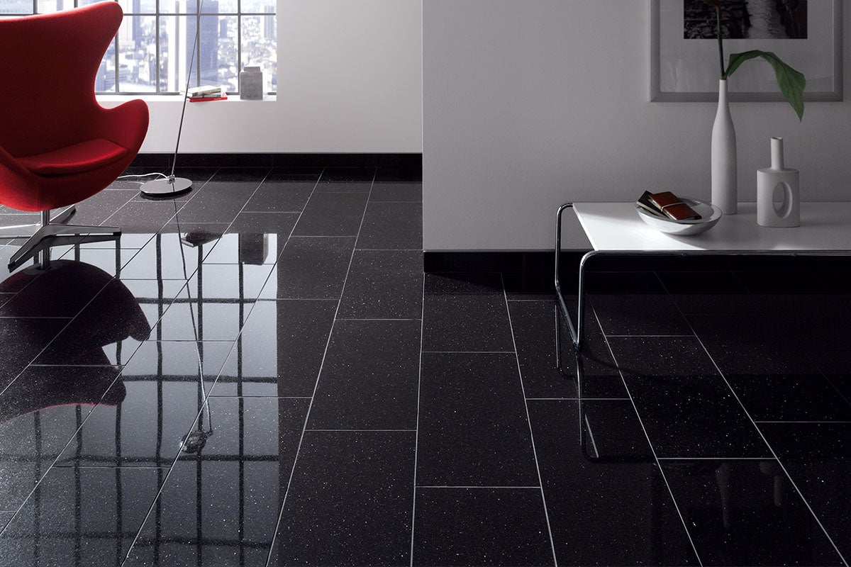 Zwarte vloertegels in een moderne woonkamer met stoel, tafel en raam