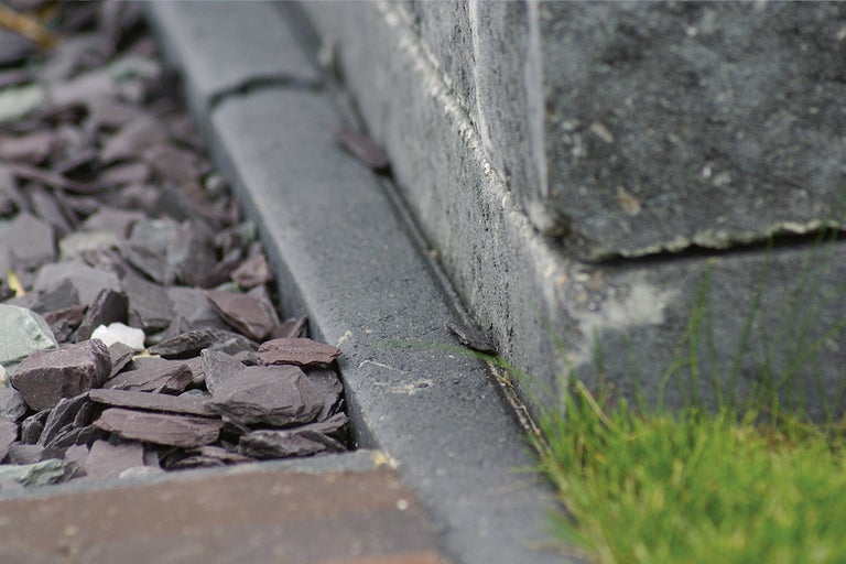 Close-up van tuinlandschap met gazonrandstenen en siersplit