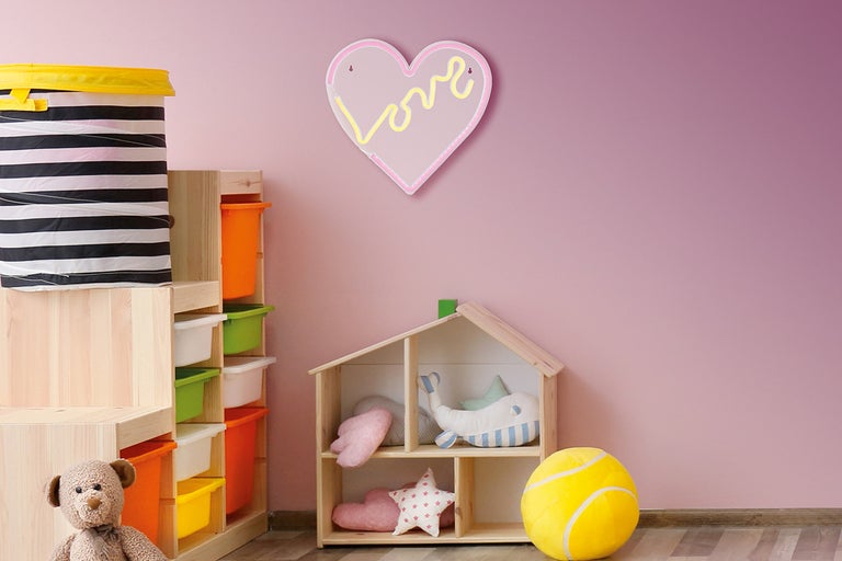 Kinderkamer met speelgoedrek, opbergmand en hartvormige wanddecoratie