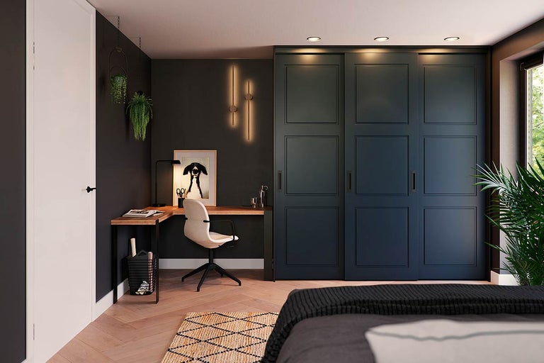 Slaapkamer met schuifdeurkast, bureau en bureaustoel.