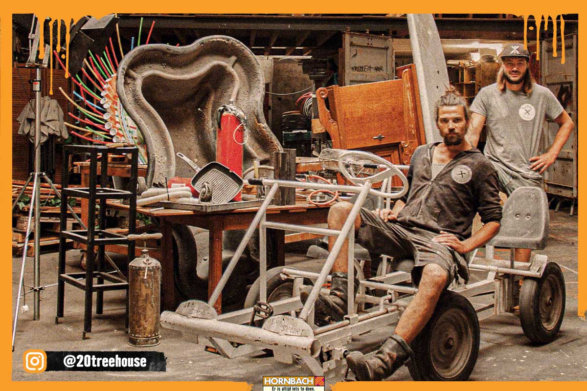 Werkplaatsopname met een zelfgemaakte trap-kart en twee personen