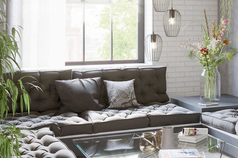 Woonkamer met modulaire bank, salontafel en decoraties voor een raam.