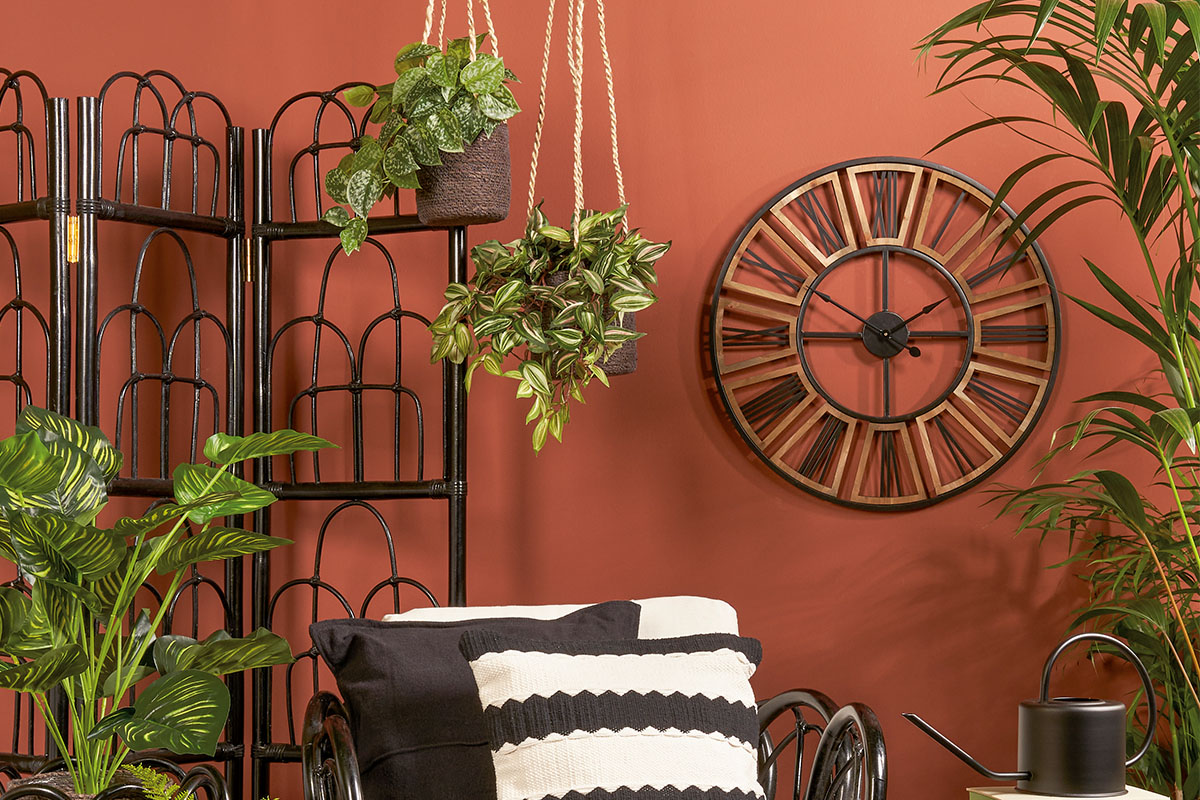 Decoratief interieur met kamerscherm, hangplanten, wandklok en kamerplanten