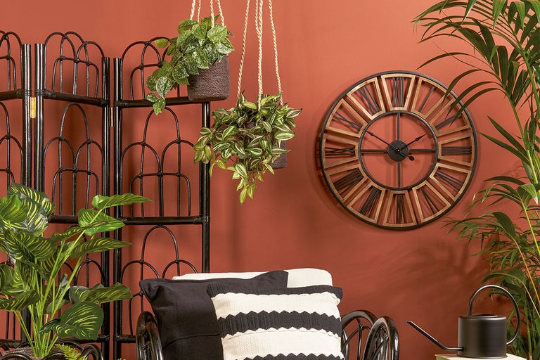 Decoratief interieur met kamerscherm, hangplanten, wandklok en kamerplanten