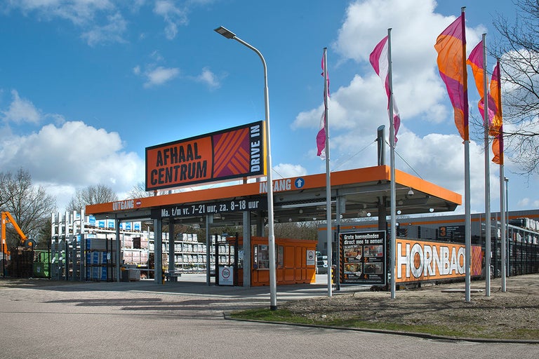 Hornbach afhaalcentrum buitenaanzicht met borden en kleurrijke vlaggen