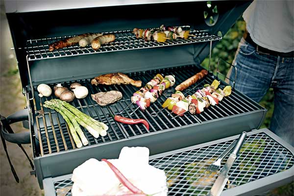Barbecue met worstjes, vlees, groenten en shaslickspiesjes op het rooster