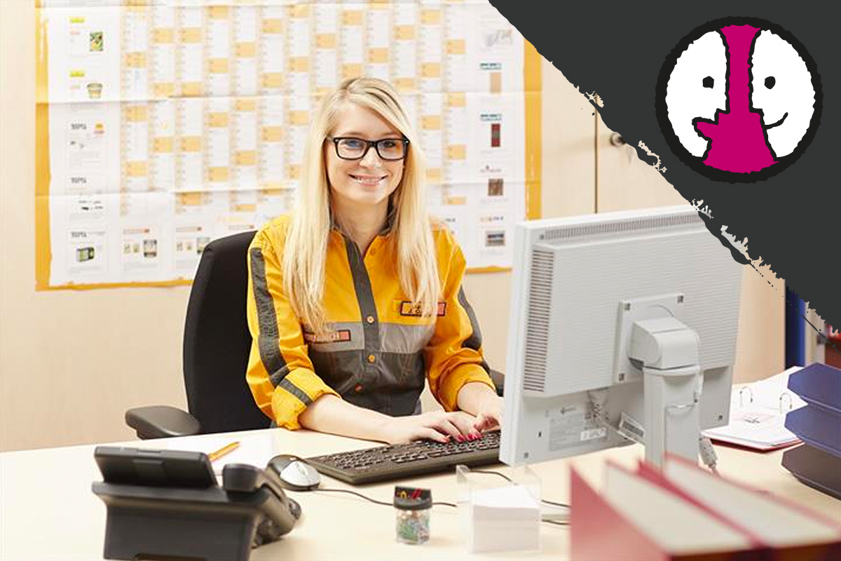 Een medewerkster zit aan een bureau met een computer in een Hornbach bouwmarkt.