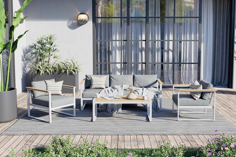 Tuinzitgroep met bank, stoelen en tafel op een terras