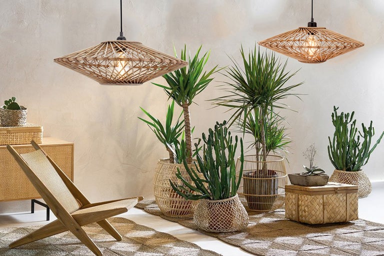 Decoratieve woonkamer met hanglampen van rotan, stoel en kamerplanten in gevlochten manden.