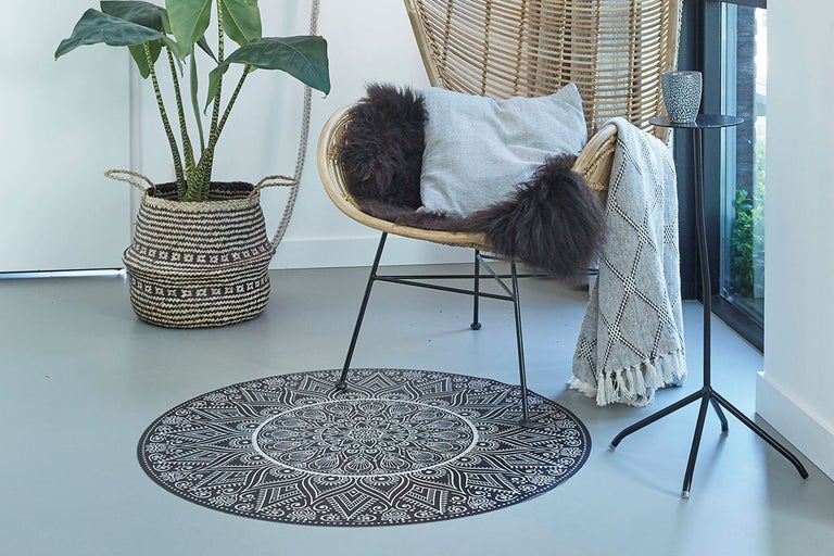 Decoratieve ruimte met vloerkleed, fauteuil, bijzettafel en kamerplant