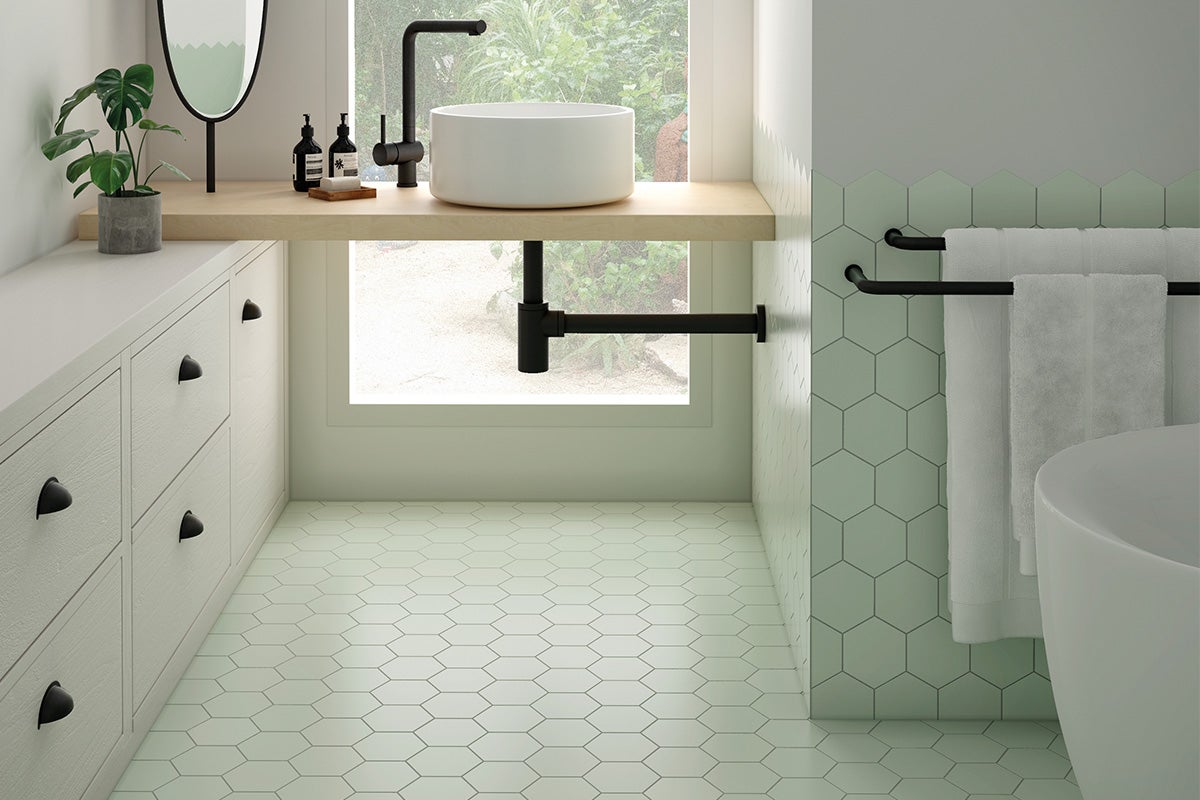 Badkamer met wastafel, spiegel, handdoekrek en zeshoekige tegels