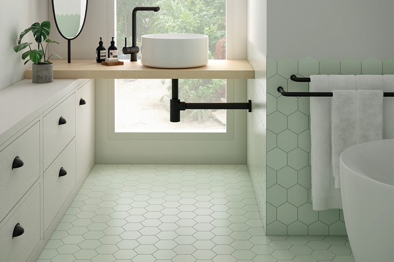 Badkamer met wastafel, spiegel, handdoekrek en zeshoekige tegels