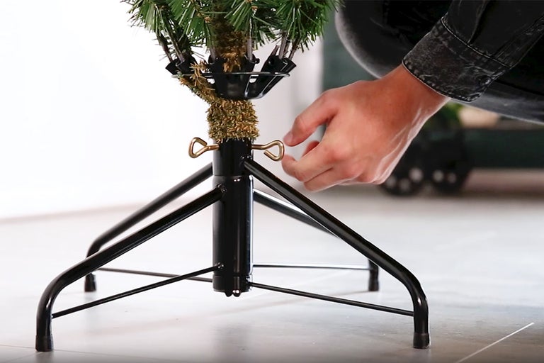 Montage van een kunstkerstboom met metalen standaard