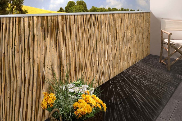 Balkon met rieten privacyscherm en houten stoel