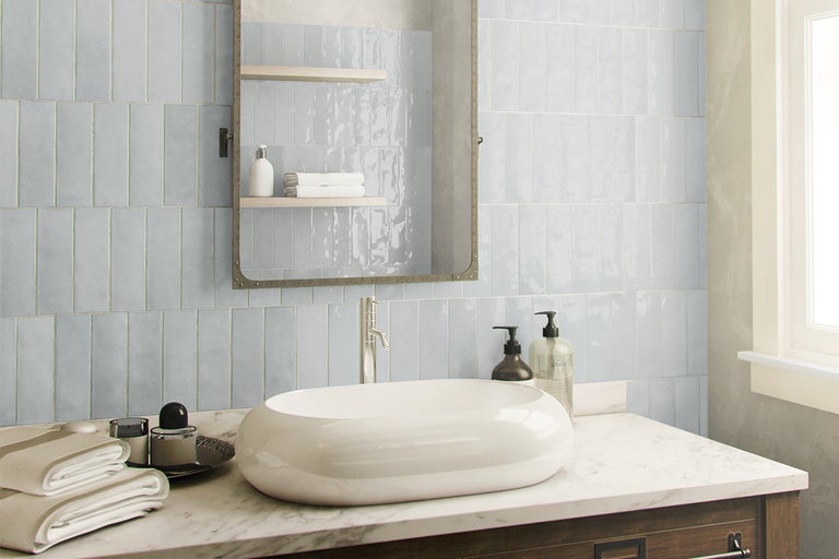 Lichte badkamer met waskom en blauwe wandtegels