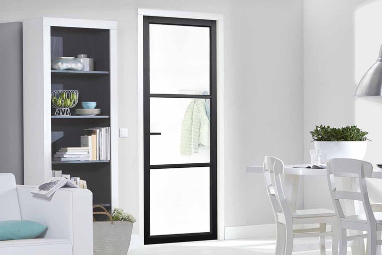 Kamerdeur met glazen inzetstukken en zwart kozijn in lichte omgeving