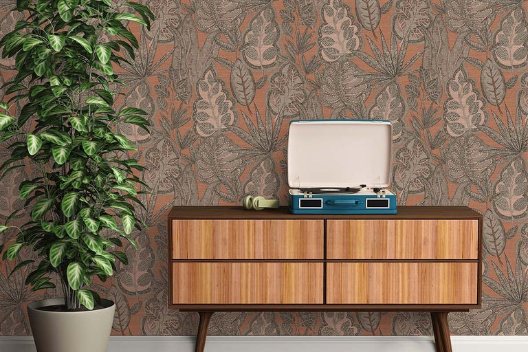 Decoratieve scène met kamerplant, dressoir, platenspeler en hoofdtelefoon voor een behang met motief.