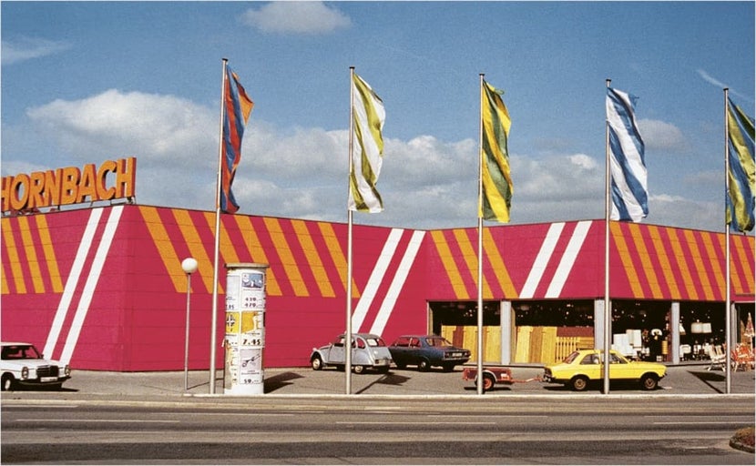 Exterieur van een Hornbach bouwmarkt met gevel, logo en meerdere vlaggen